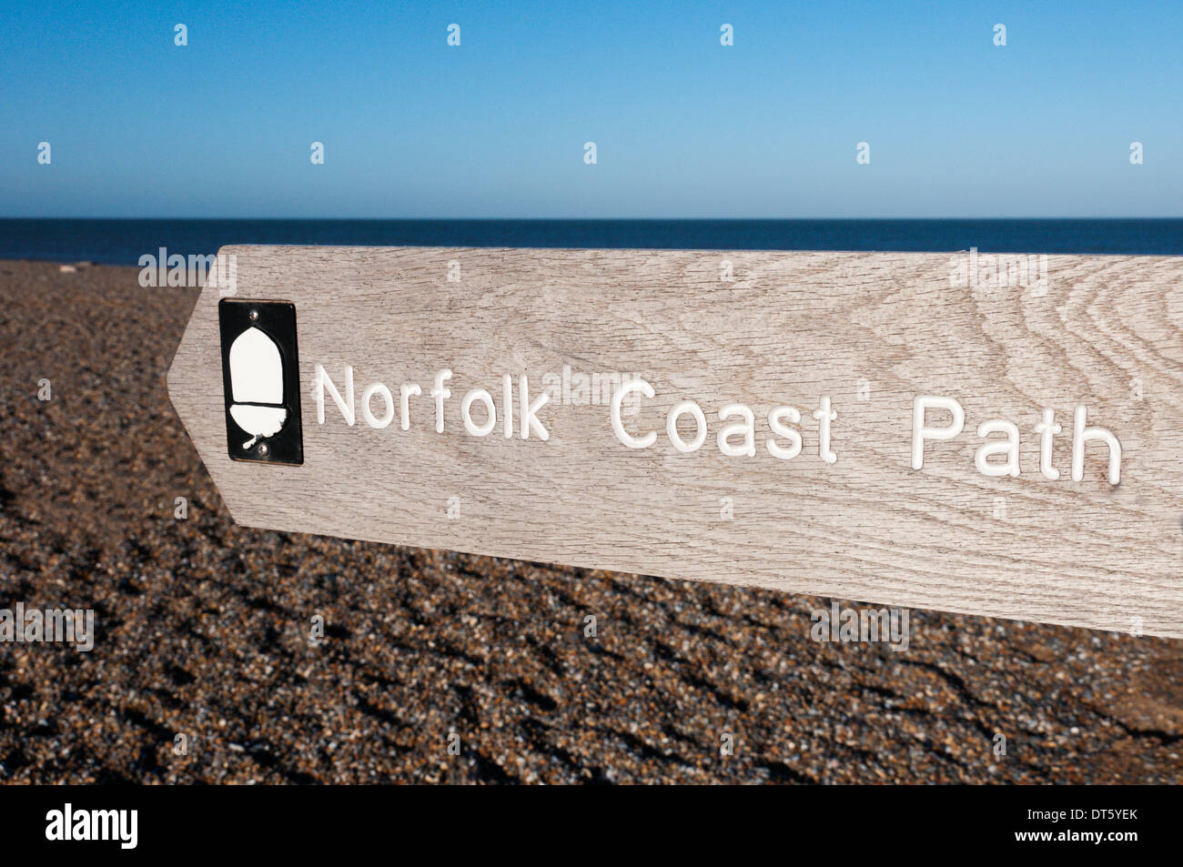 Ein Wegweiser für die Norfolk Küstenpfad nach links oder nach Westen entlang der Kiesstrand am Salthouse in North Norfolk. Stockfoto