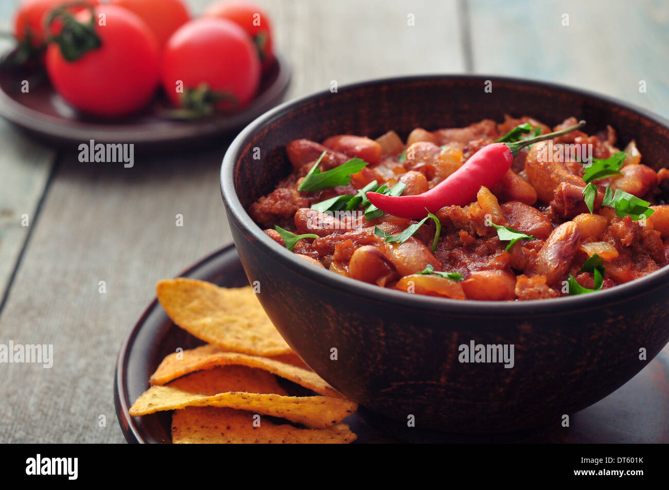 Chili Con Carne in Schüssel mit Tortilla-Chips auf hölzernen Hintergrund Stockfoto