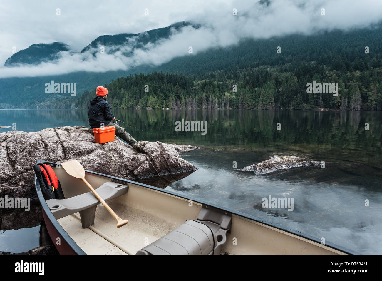 Mann Angeln vom Felsen, Buntzen Lake, British Columbia, Kanada Stockfoto