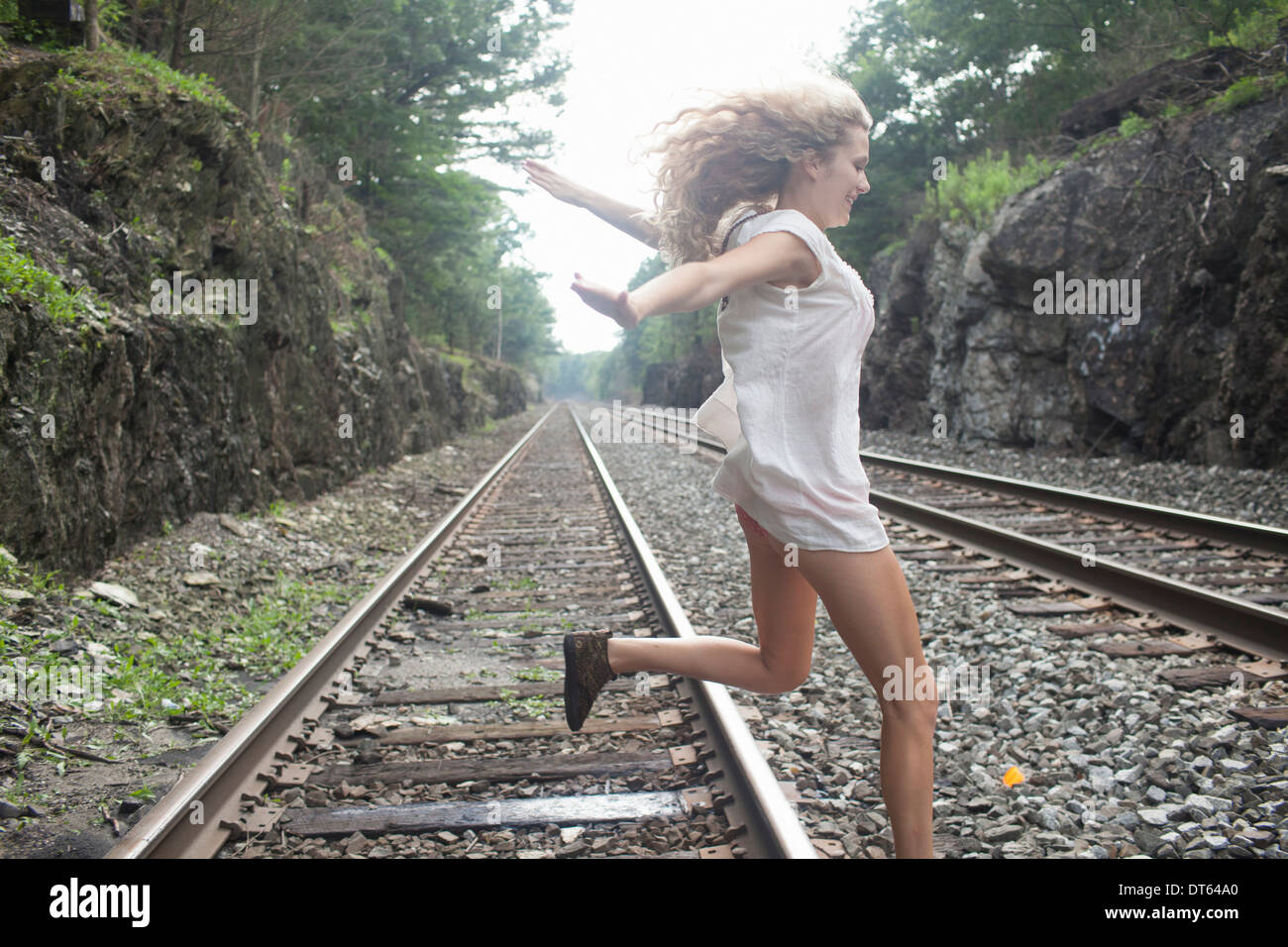 Teenager-Mädchen springen über Gleis Stockfoto