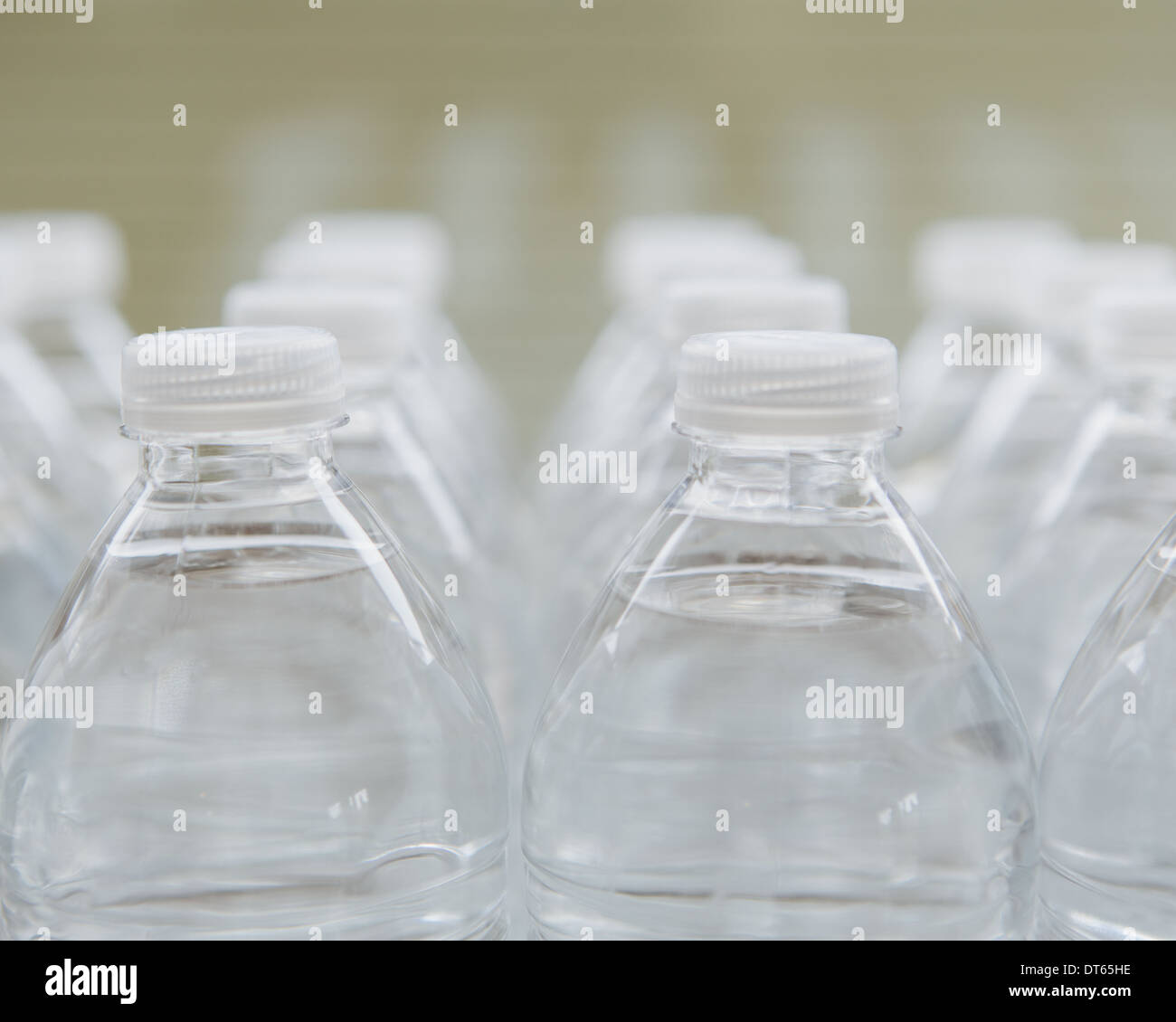 Zeilen mit Wasser gefüllte PET-Flaschen mit Schraubverschlüssen. Stockfoto