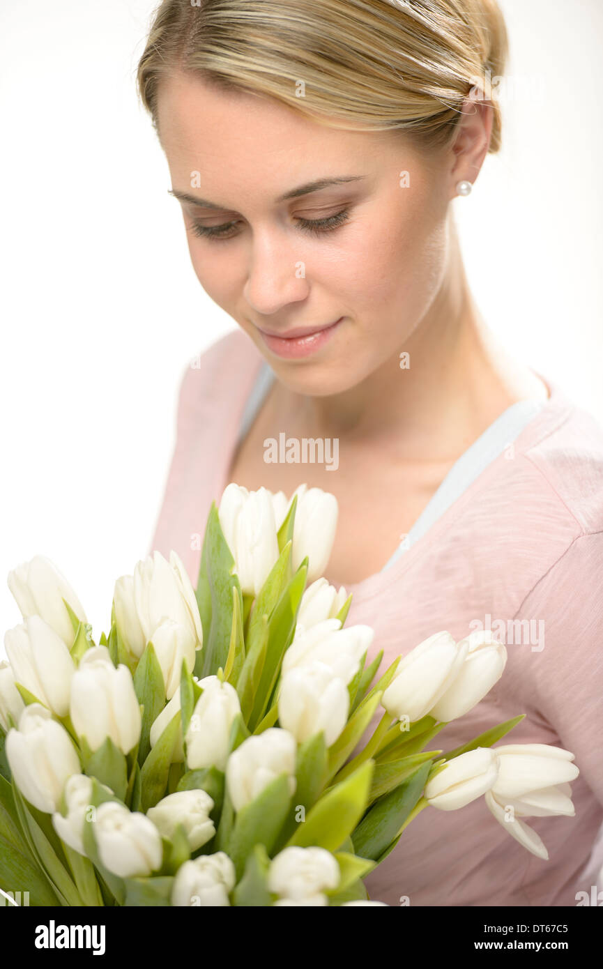 Schöne Frau auf der Suche nach weißen Blumen Frühlingsstrauß Tulpen Stockfoto