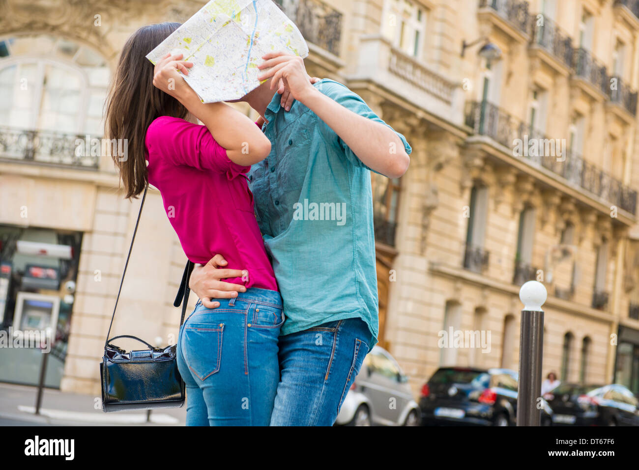 Junges Paar versteckt sich hinter Karte, Paris, Frankreich Stockfoto