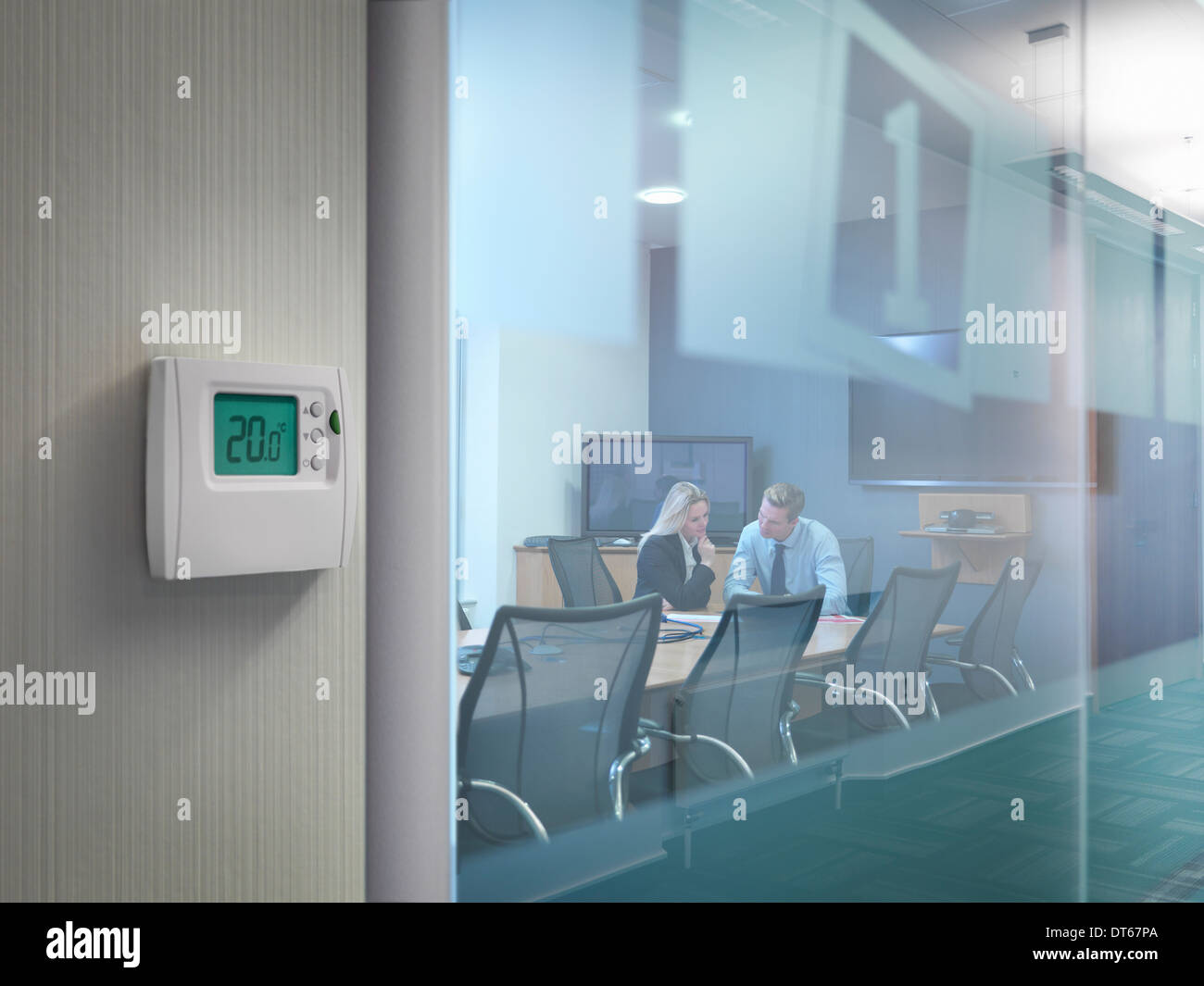 Thermostat außerhalb Konferenzraum mit Büroangestellte in treffen Stockfoto