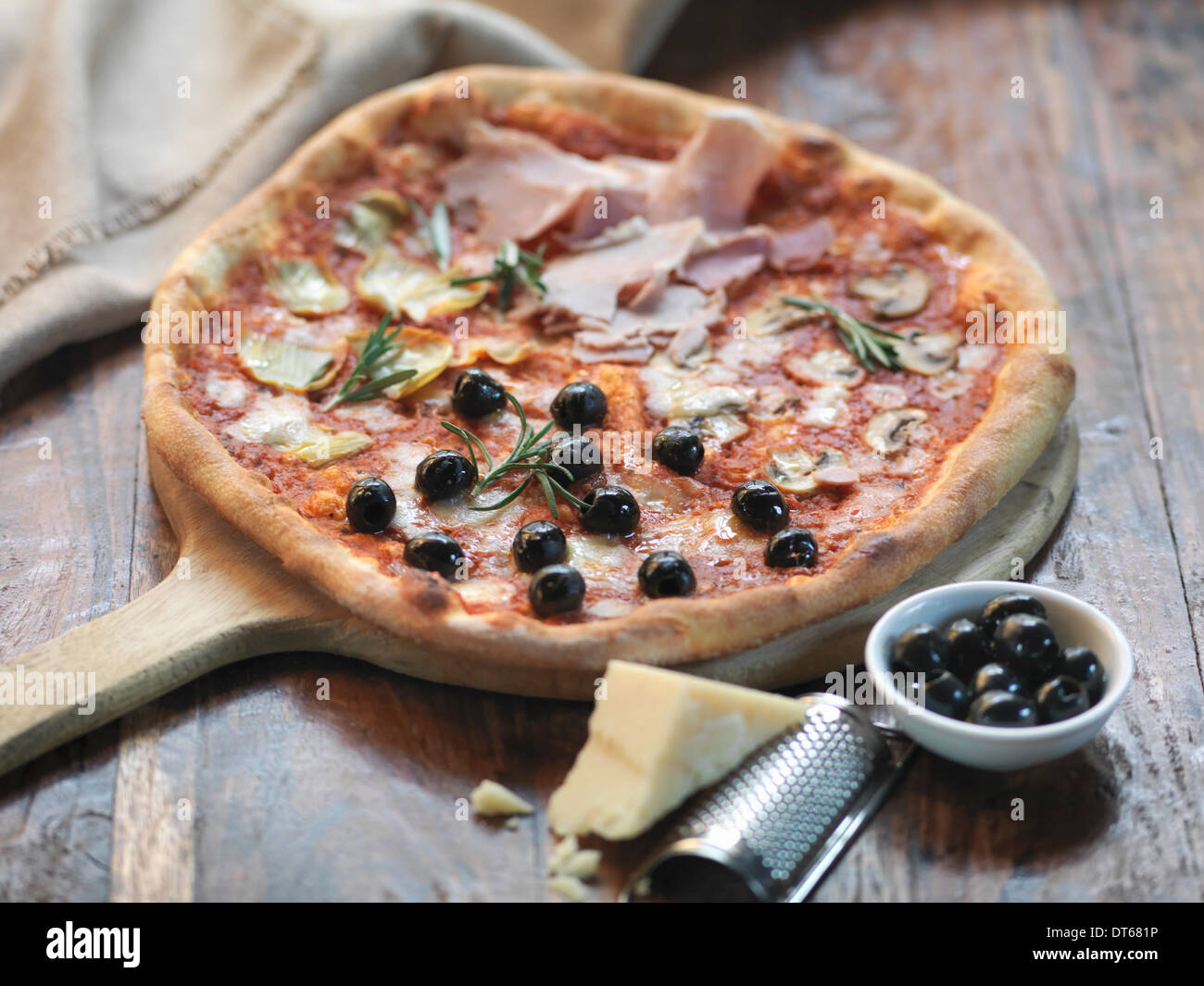 Hausgemachte Quattro Stagioni Pizza mit Schinken, Artischocken, Oliven, Champignons und Mozzarella-Käse Stockfoto