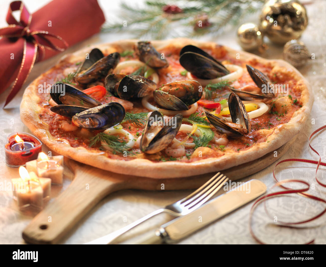Hausgemachte Meeresfrüchte Pizza mit Tintenfisch, Garnelen und Muscheln mit festlichen Dekorationen Stockfoto