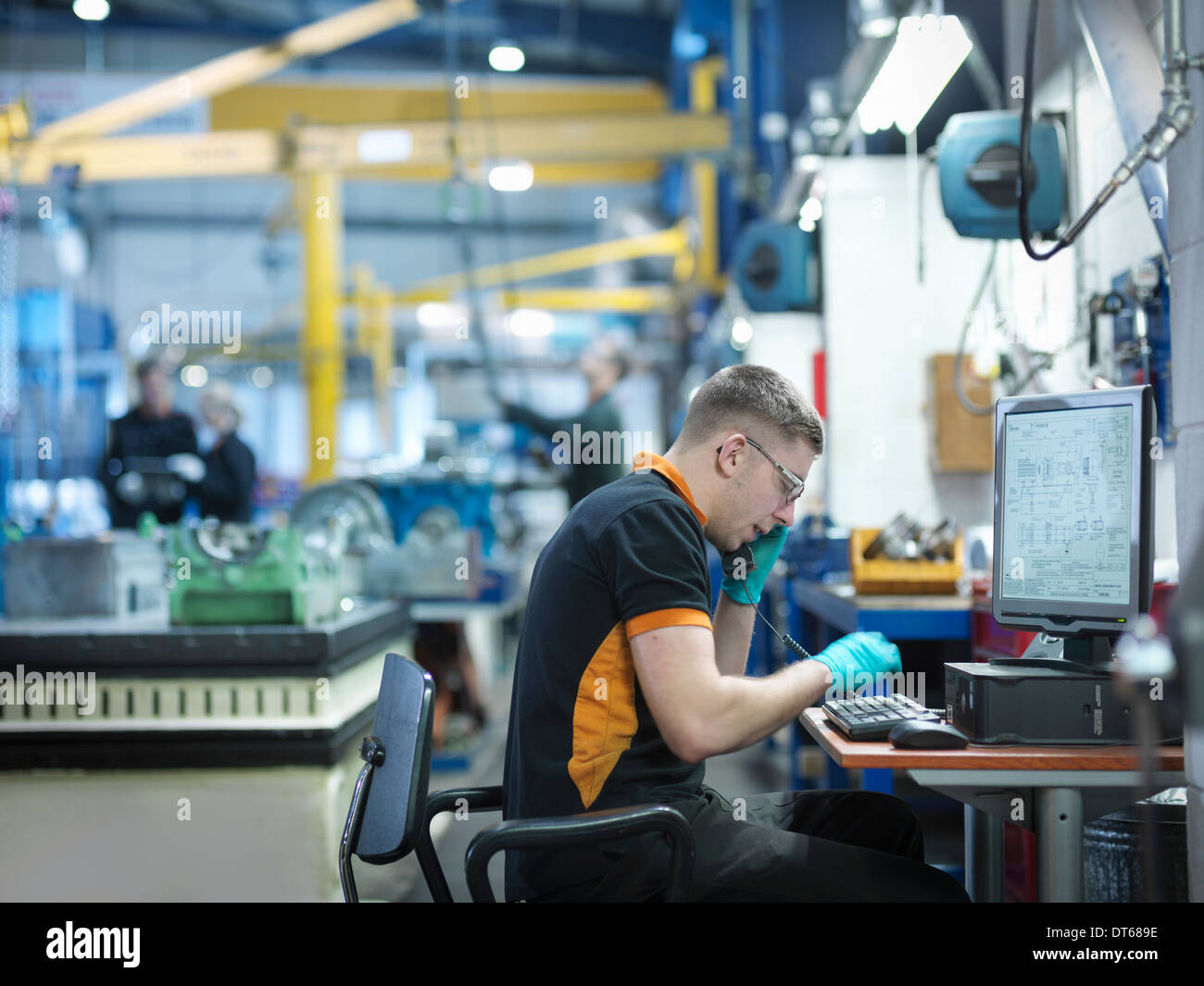 Ingenieur mit Telefon und Computer in engineering-Fabrik Stockfoto