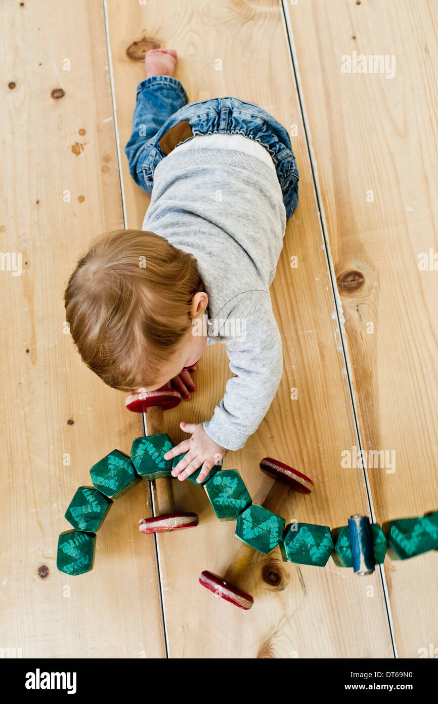 Studioaufnahme von Babymädchen spielt mit Rädern Spielzeug Stockfoto