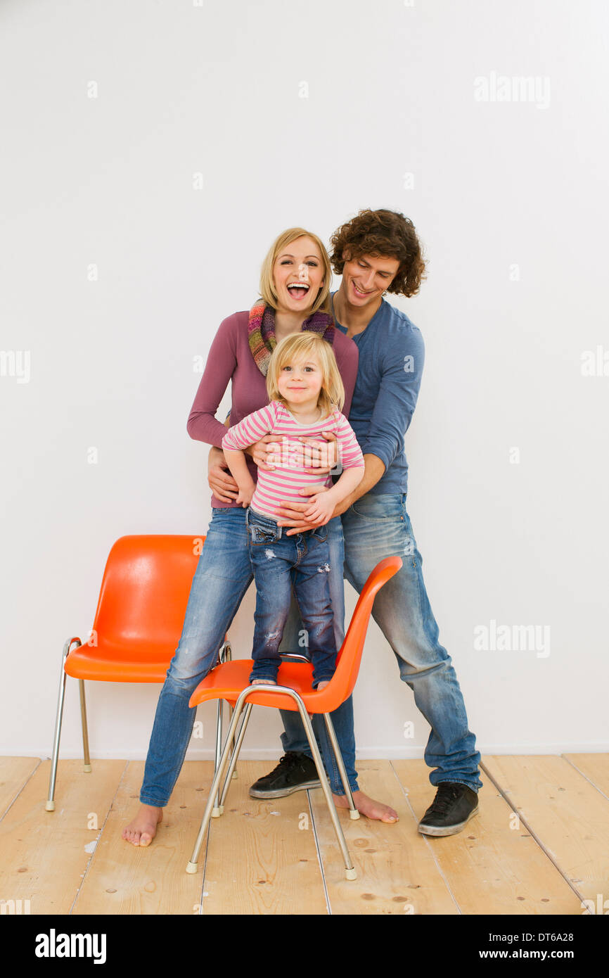 Studioaufnahme des Paares mit Tochter auf Stuhl Stockfoto