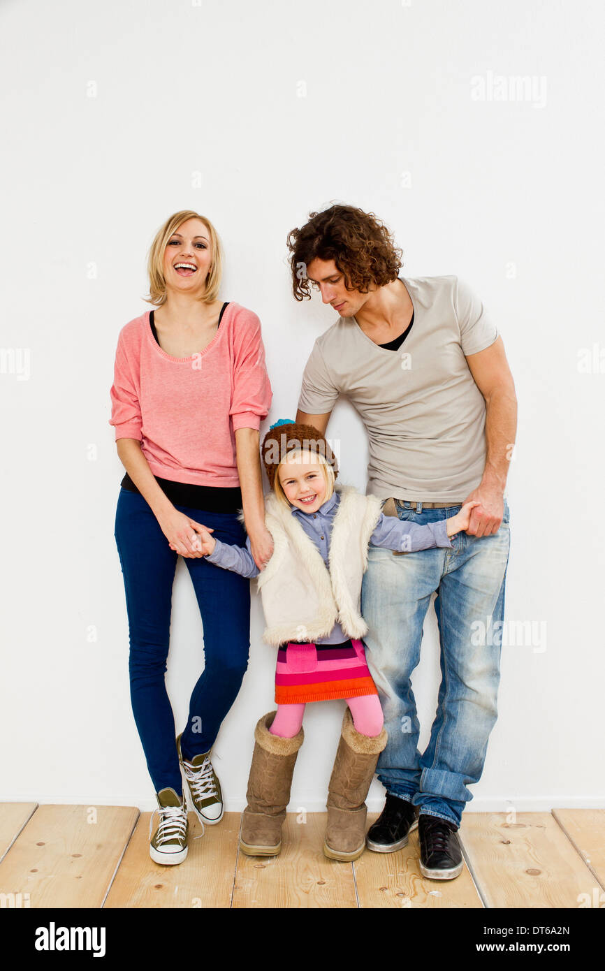 Studioaufnahme des Paares mit kleinen Tochter mit großen Stiefeln Stockfoto