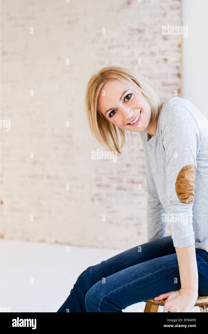 Blond woman sitting on stool -Fotos und -Bildmaterial in hoher Auflösung –  Alamy
