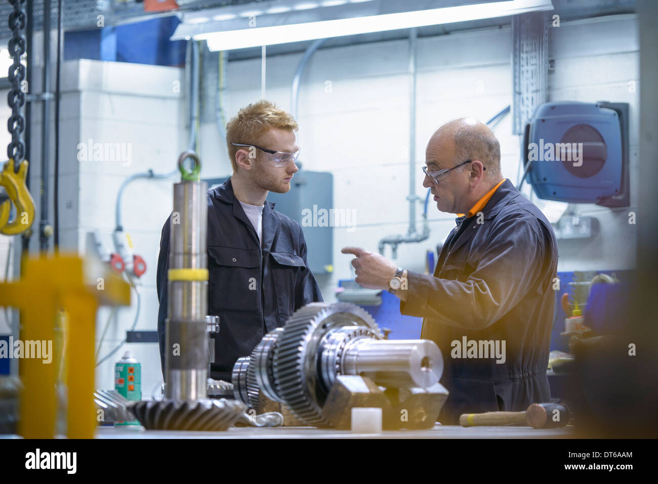 Ingenieur anweist Lehrling am Arbeitsplatz in der Fabrik Stockfoto