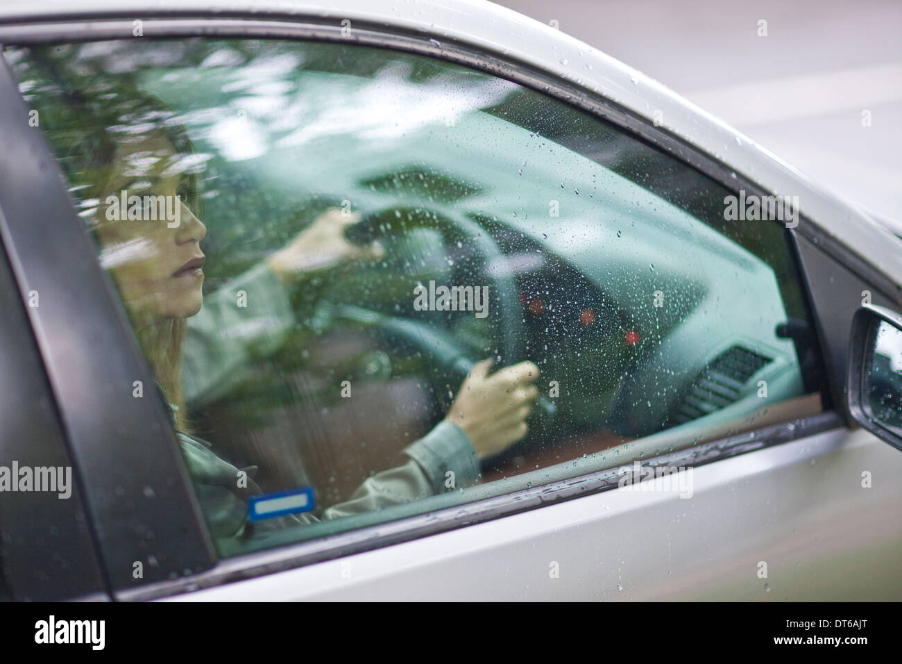 Junge Frau sitzt im Auto Blick aus Fenster Stockfoto