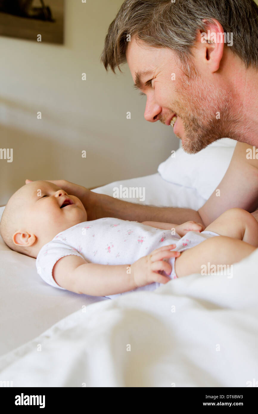 Vater und Baby Tochter auf Bett Stockfoto