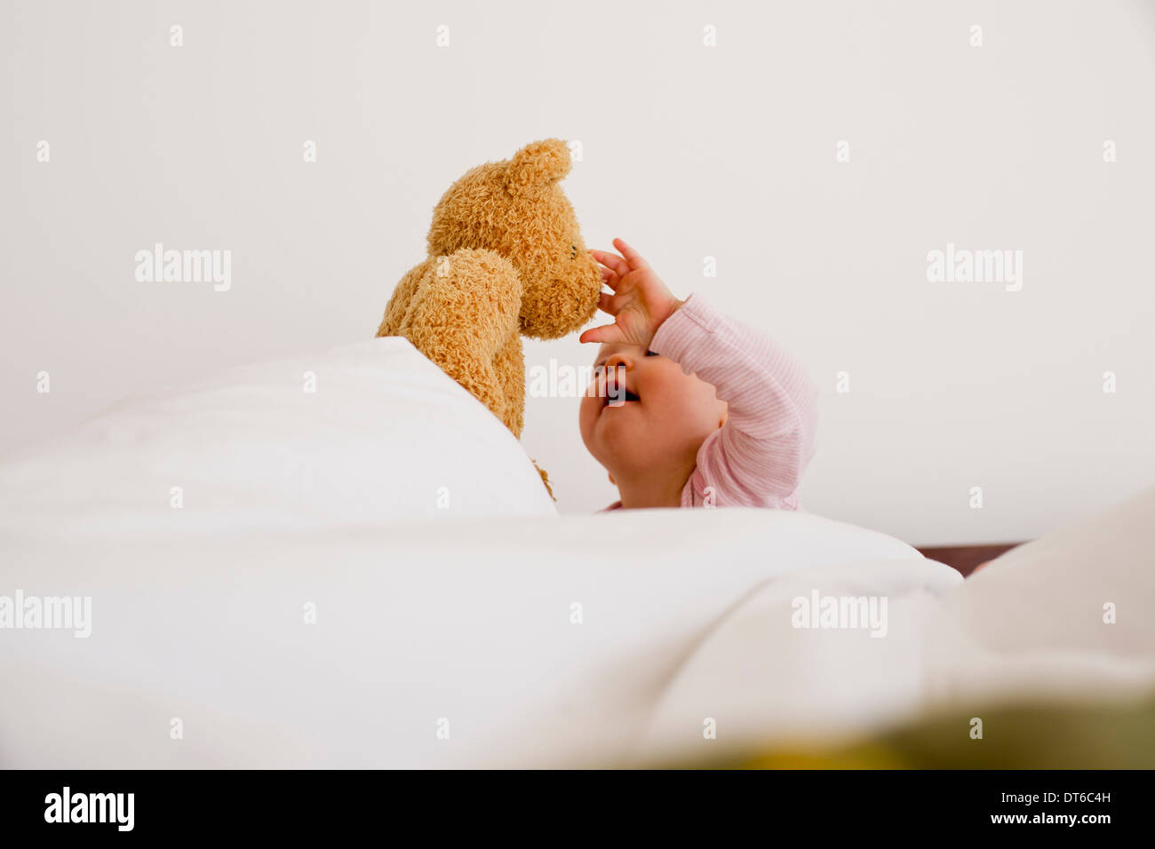 Babymädchen spielen mit Teddybär Stockfoto
