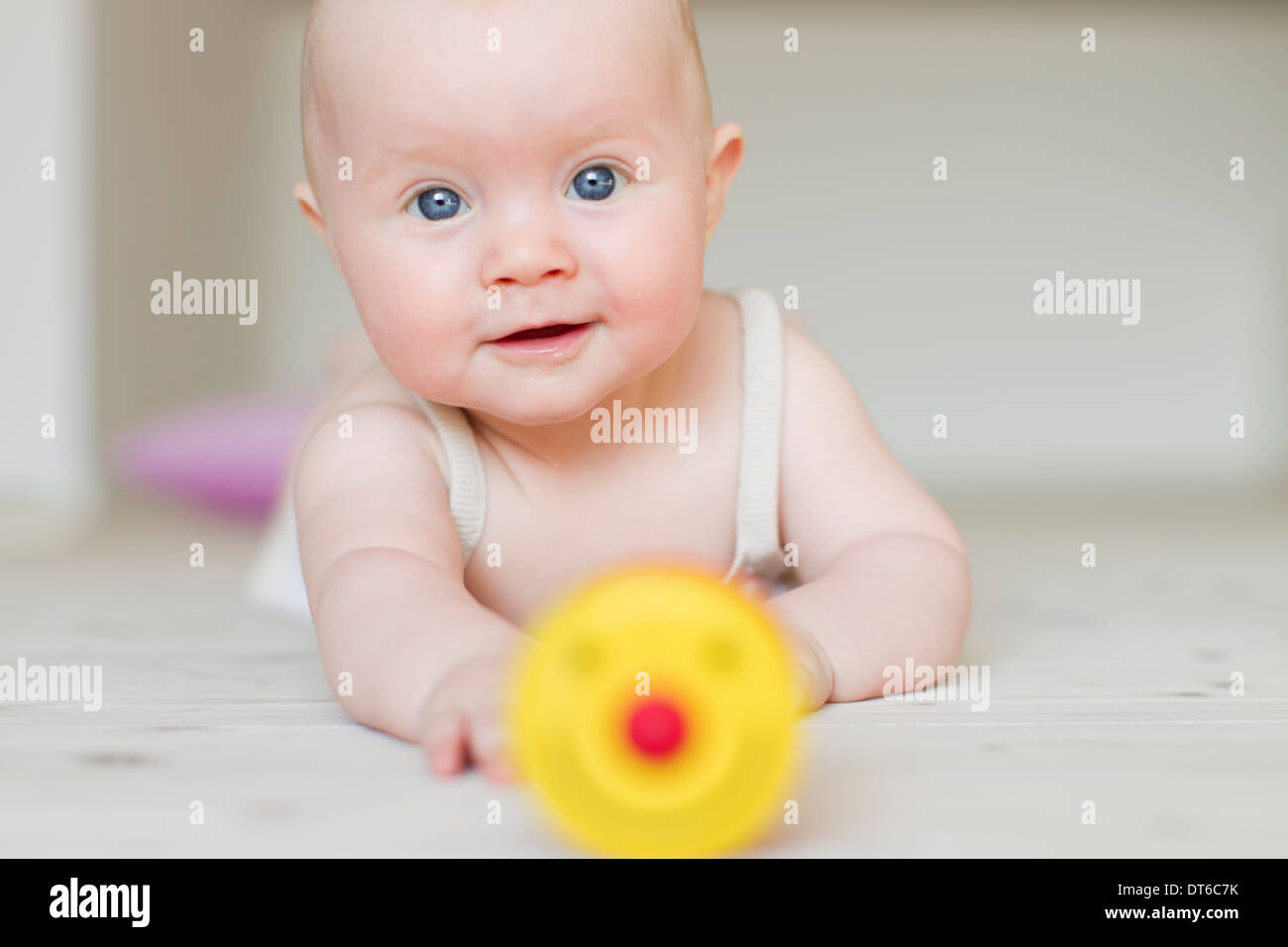 Babymädchen mit Spielzeug im Vordergrund Stockfoto