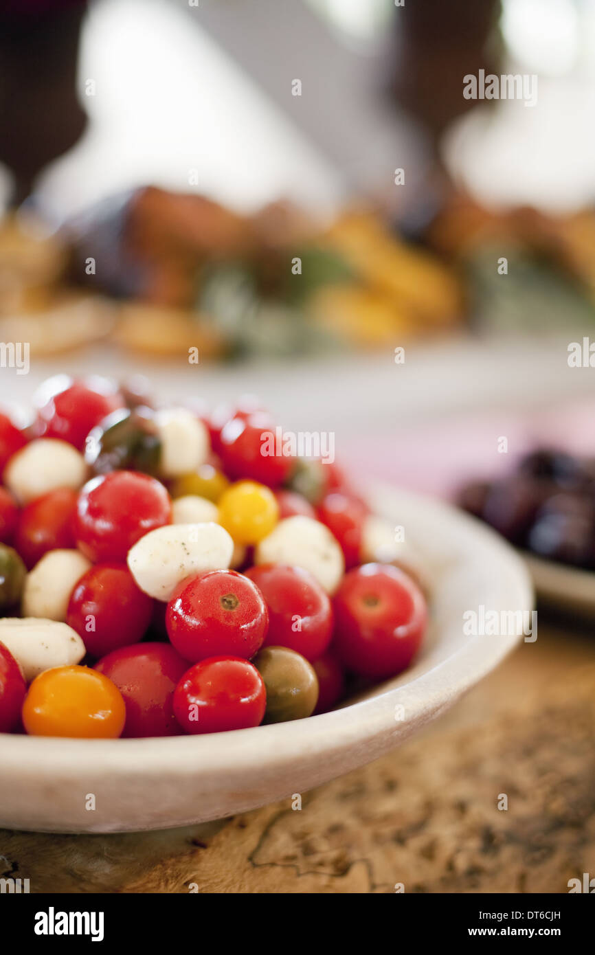 Gemüse auf einem Teller ausgelegt für eine Party.  Rot und orange Urtomaten und Bocancini Salat. Ein Bauernhof stand Garküche. Stockfoto