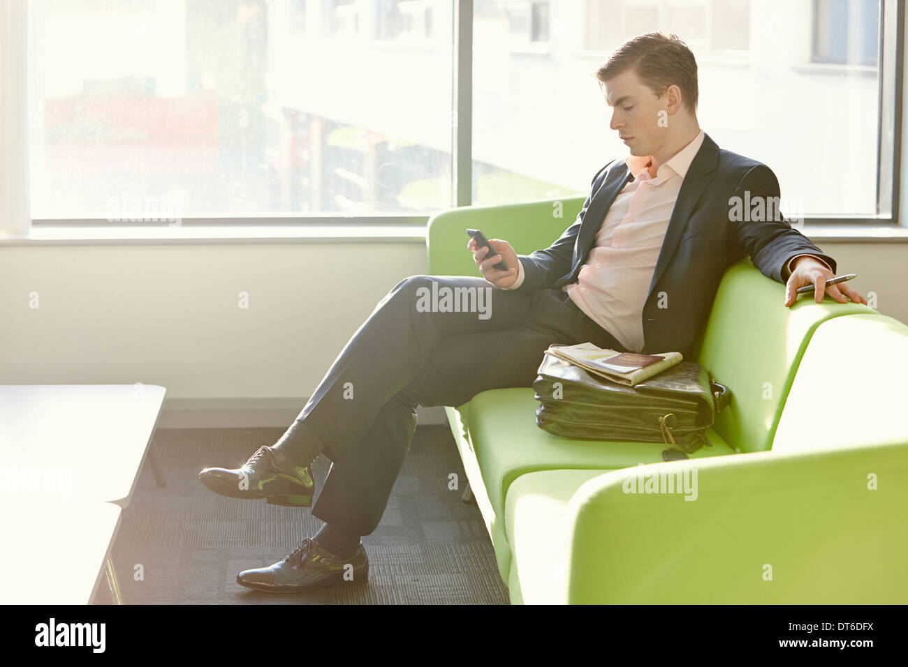 Geschäftsmann in der Abflug-Lounge mit Handy Stockfoto