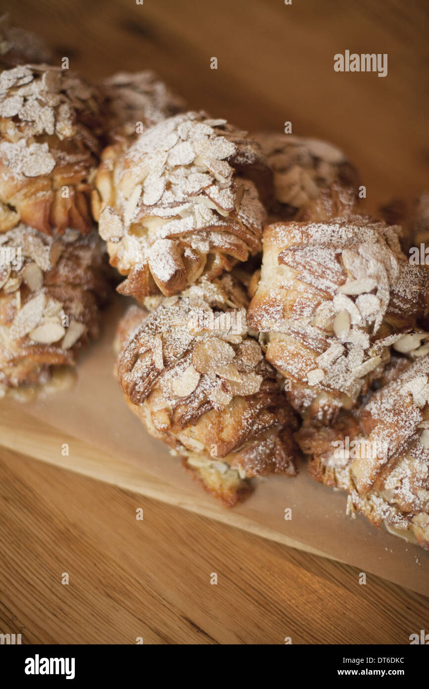 Eine Gruppe von frisch gebackene Mandel Croissants mit Puderzucker Zucker bestäuben. Bio-Party Essen Nachtisch. Stockfoto