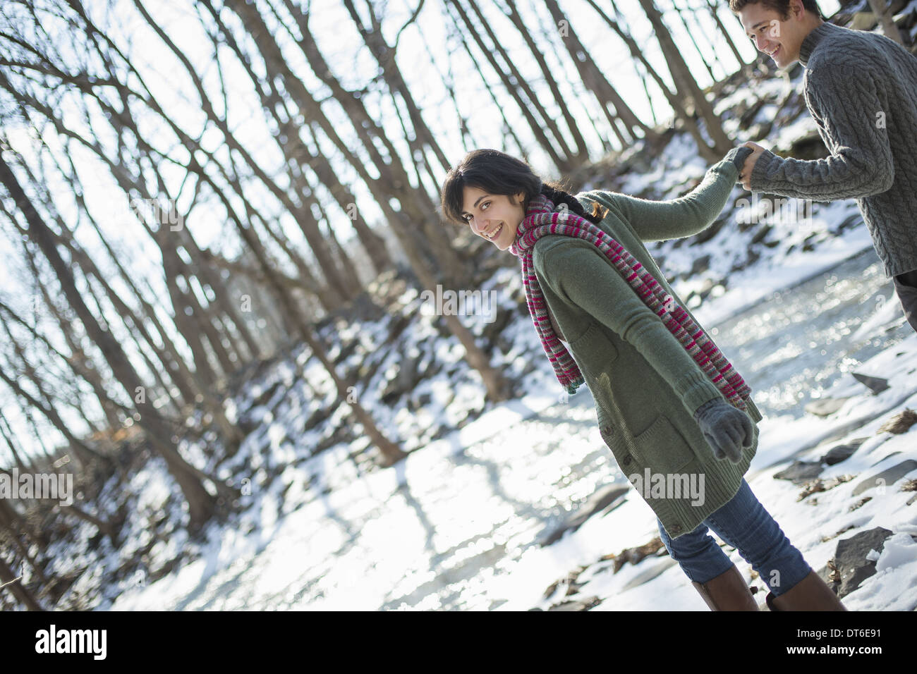 Ein paar hand in hand auf einem verschneiten Pfad durch den Wald. Stockfoto
