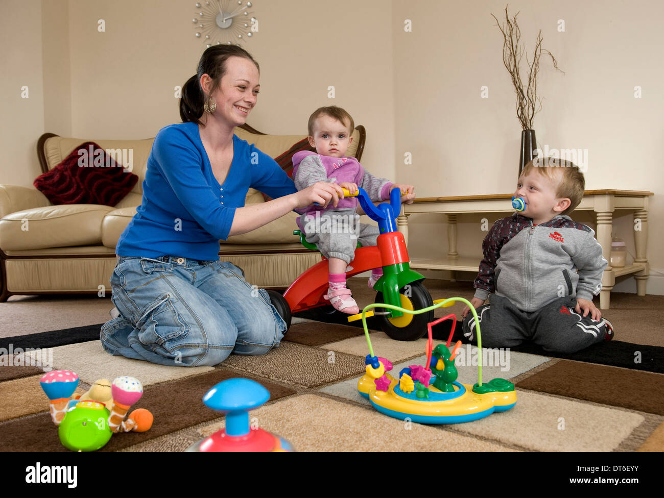 Eine junge Mutter mit ihren beiden Kindern zu Hause spielen. Stockfoto