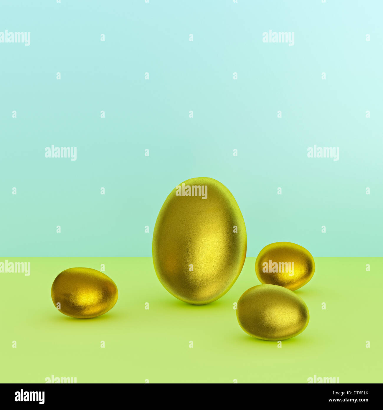 Stillleben mit einem großen und drei kleinen goldenen Eiern Stockfoto