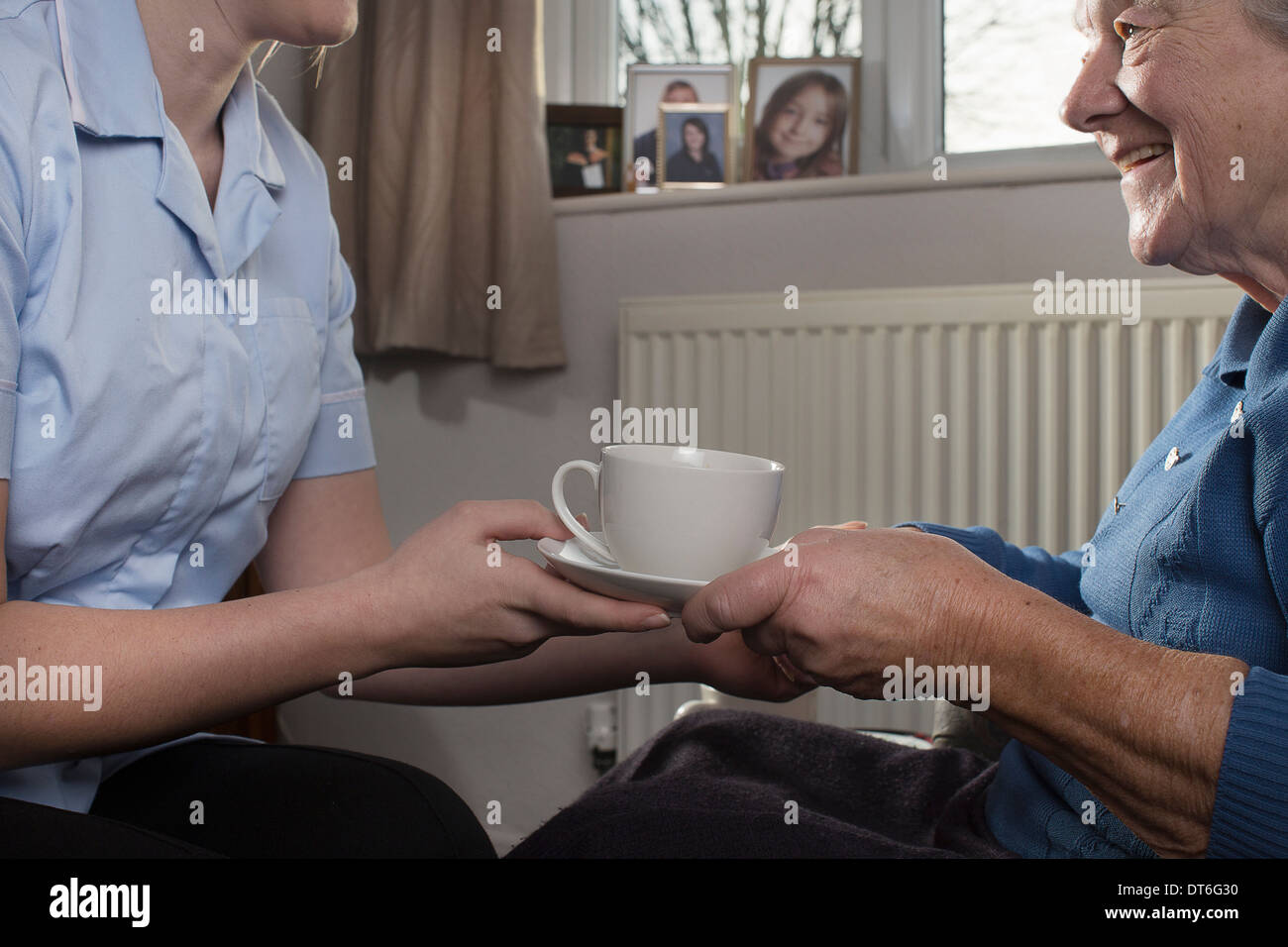 Körperpflege-Assistent Übergabe senior Frau Tasse Tee Stockfoto