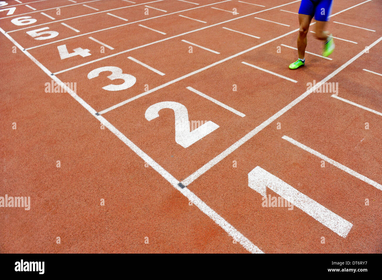 Verschwommene Athleten durch eine langsame Kamera Verschlusszeit über die Ziellinie nach Sprint track Stockfoto