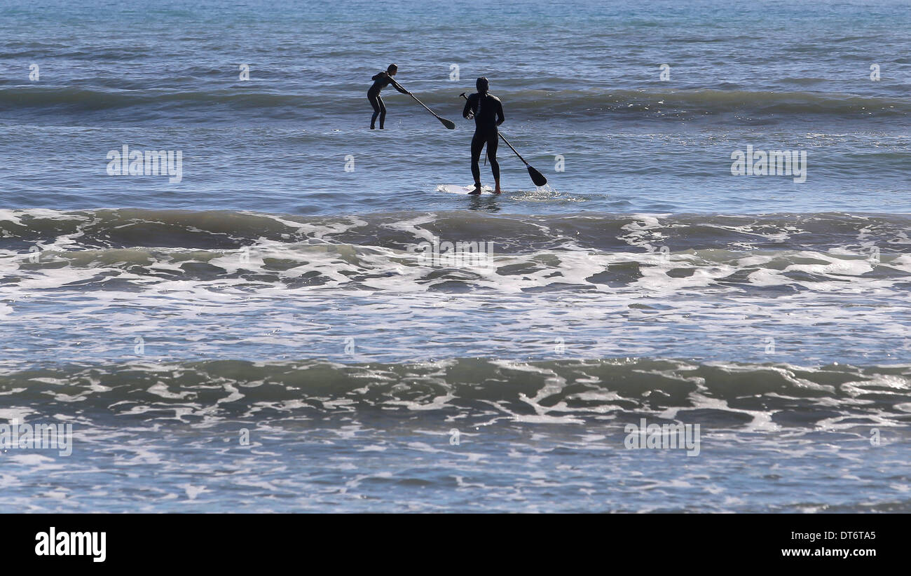 Menschen Sie Praxis SUP, stehen Sie Paddel, an einem Strand auf der Insel Mallorca auf, Spanien Stockfoto