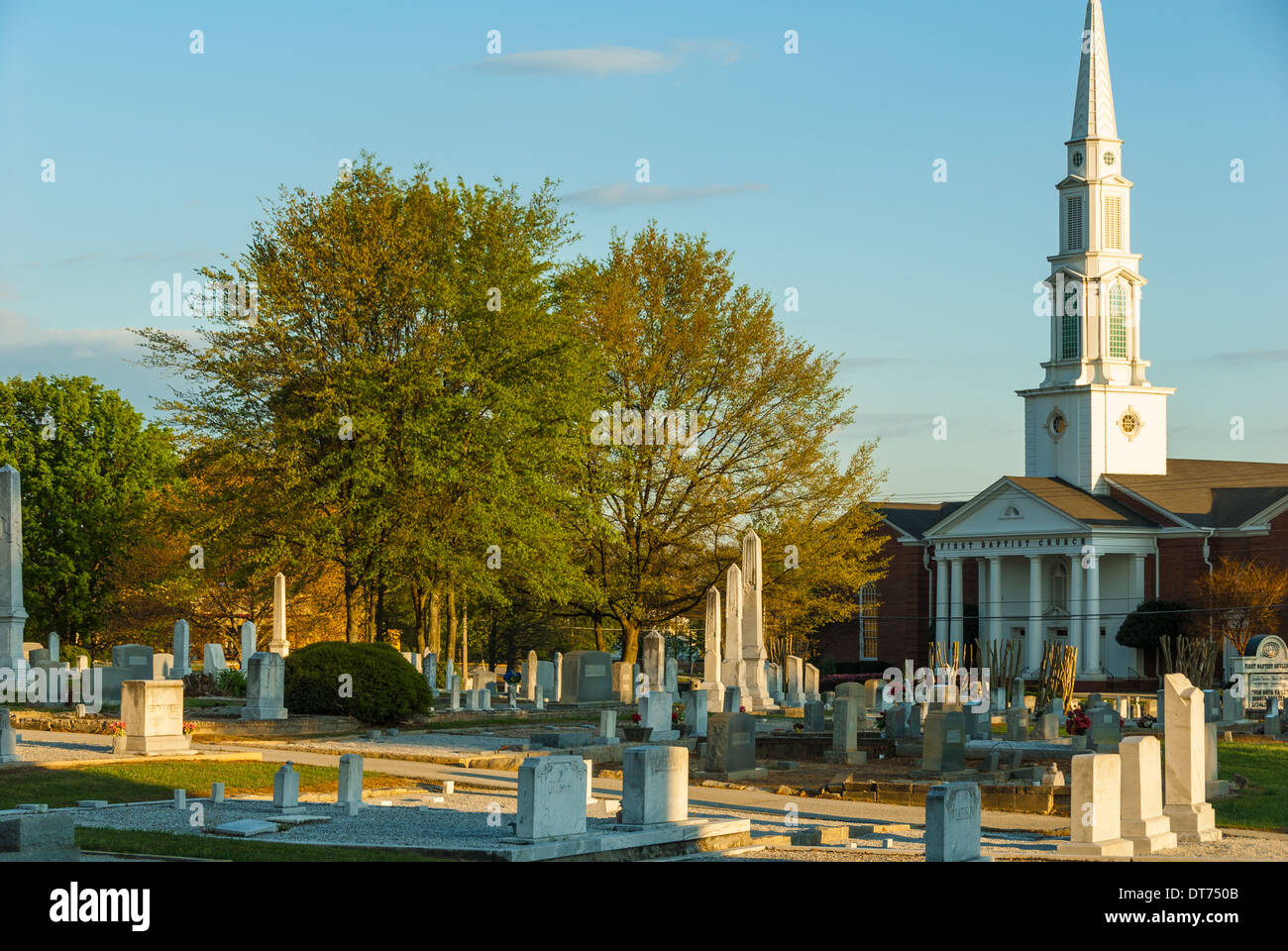 Die untergehende Sonne zeigt die Wahrzeichen und Monolithen des Snellville Historical Cemetery und der First Baptist Church in Snellville, Georgia. (USA) Stockfoto