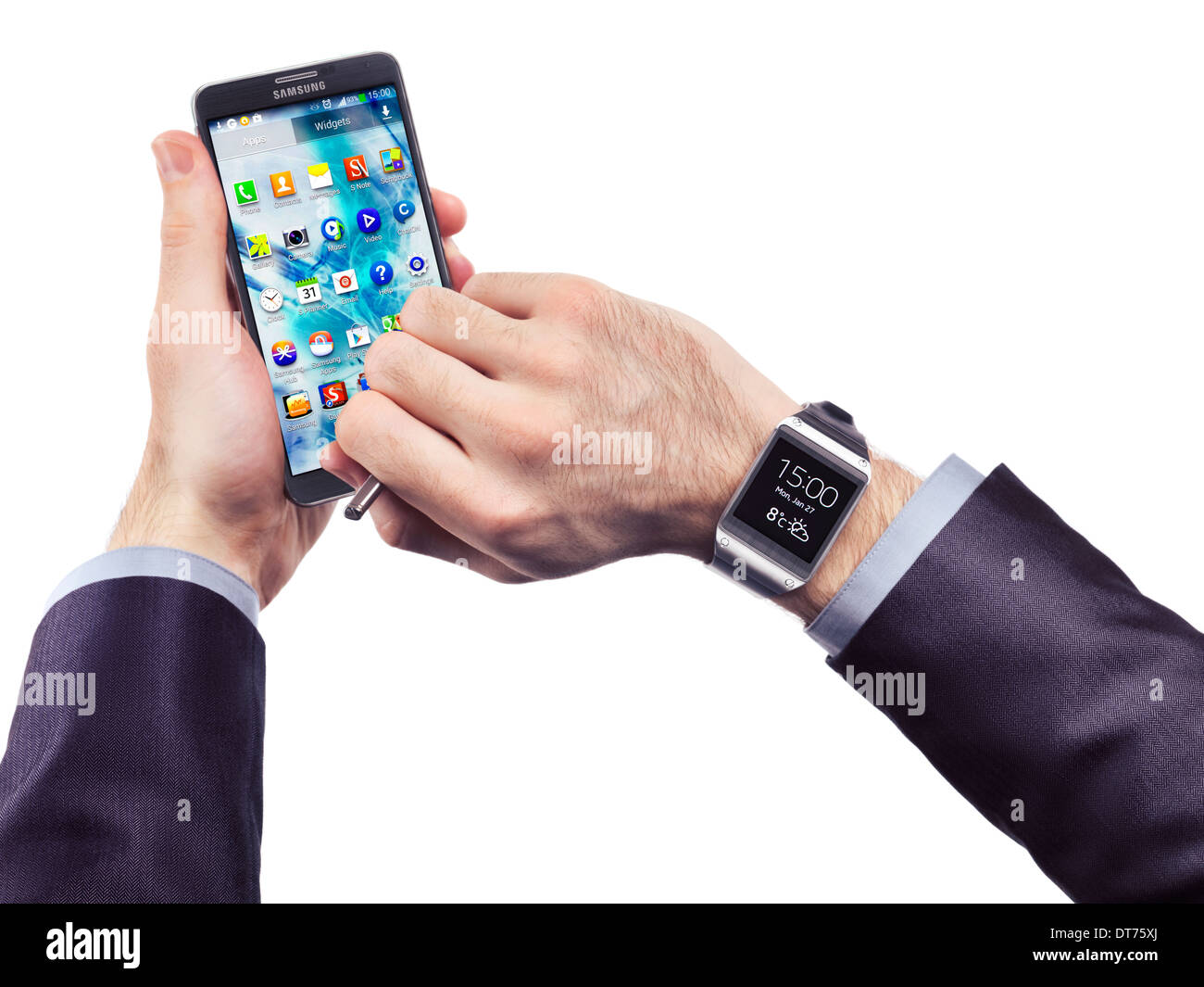 Hände einer Person trägt Samsung Galaxy Gear Uhr und hält Galaxy Note 3 Smartphone isoliert auf weißem Hintergrund Stockfoto