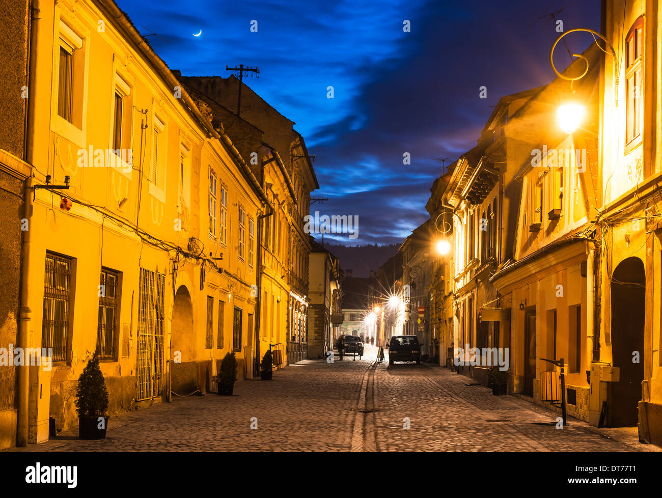 Brasov, Transylvania. Nachtaufnahme des Mittelalters gepflasterte Strasse in der Innenstadt der Stadt. Sächsischer Meilenstein in Rumänien. Stockfoto