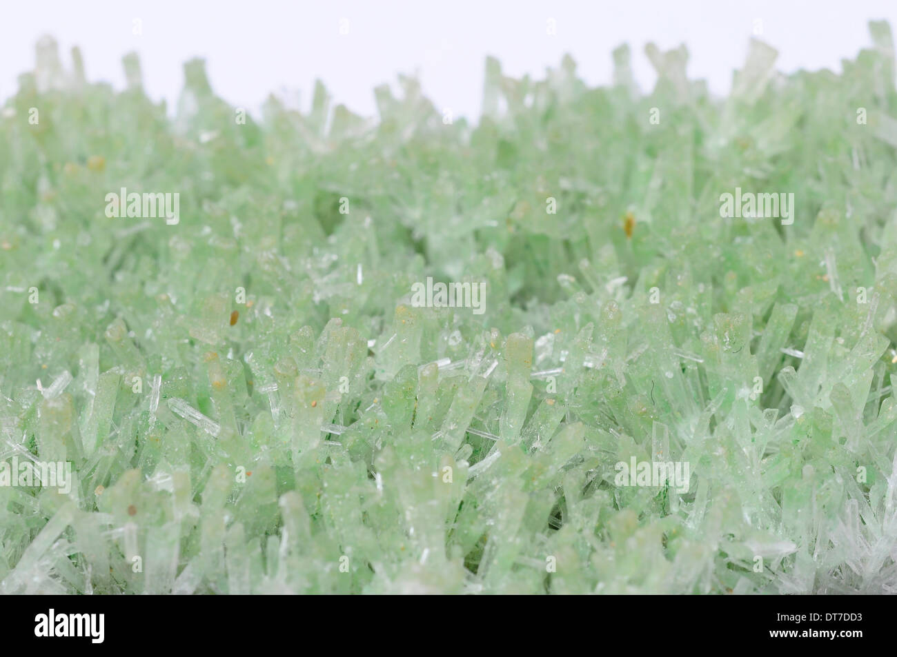 Schließen Sie oben und Makro grüne Kristalle auf hellem Hintergrund Stockfoto