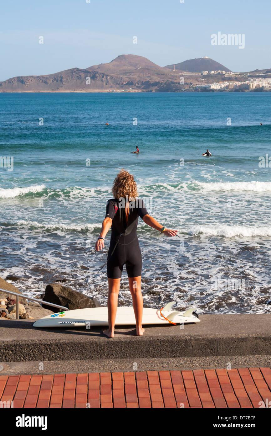 Surferin stretching am La Cicer Brandung brechen am Las Canteras Strand, Las Palmas, Gran Canaria. Kanarische Inseln Stockfoto