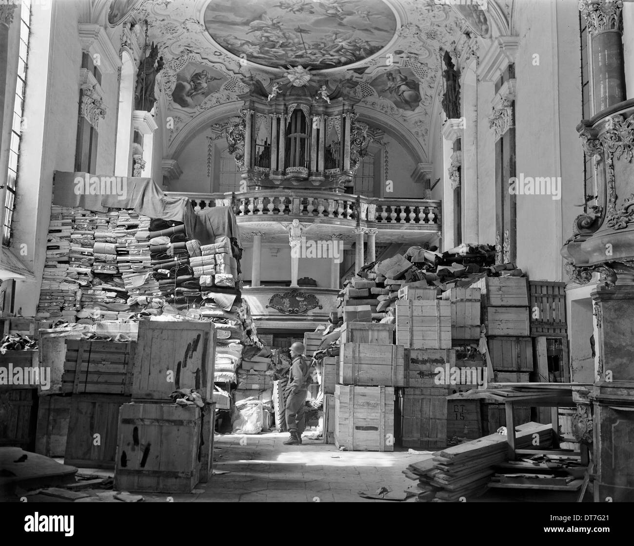 Ein US-Soldat von den Third Army Ansichten Stapeln der jüdischen Besitz Kunst geplündert von den Nazis versteckt in einer Kirche 24. April 1945 in Ellingen, Deutschland. Stockfoto