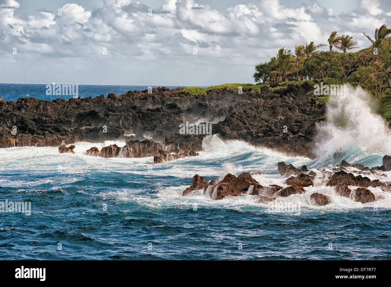 Wellen Absturz gegen die Lava Küstenlinie im Waianapanapa State Park auf Hawaii Insel Maui. Stockfoto