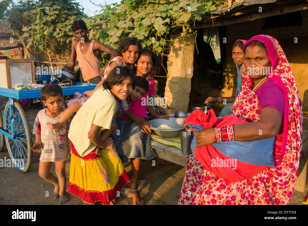 Frau in einem roten Sari und eine Gruppe von Kindern in ein Foodstall in das Dorf Sonepur zum Zeitpunkt der Sonepur Mela, Bihar, Indien Stockfoto