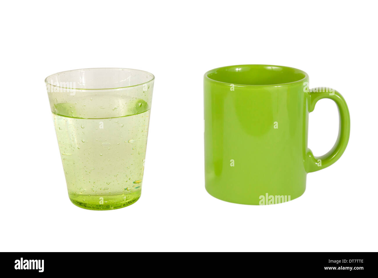 ein Glas Wasser und eine grüne Tasse isoliert auf weißem Hintergrund Stockfoto