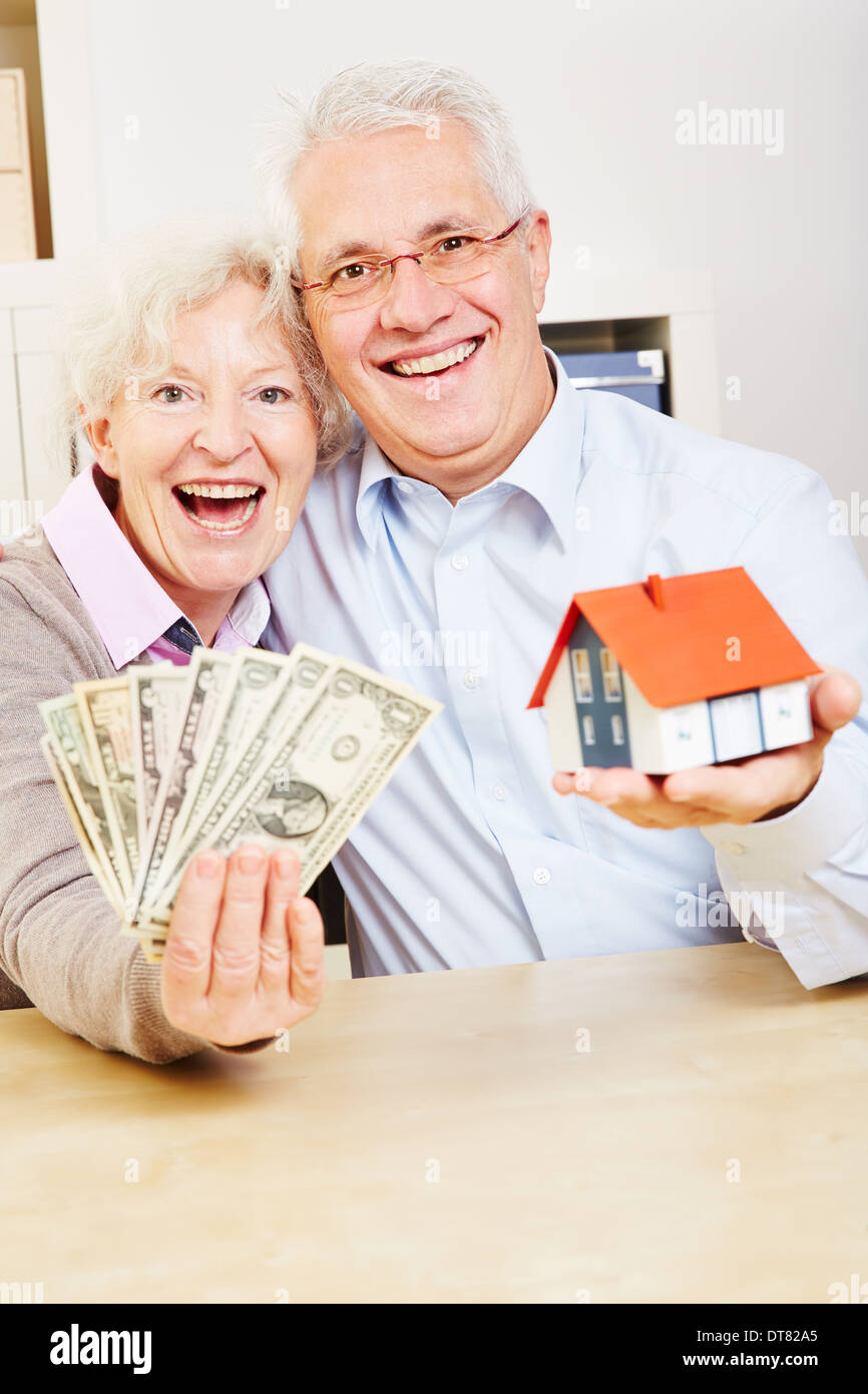 Ältere Familienglück mit Dollarnoten und ein kleines Haus Stockfoto