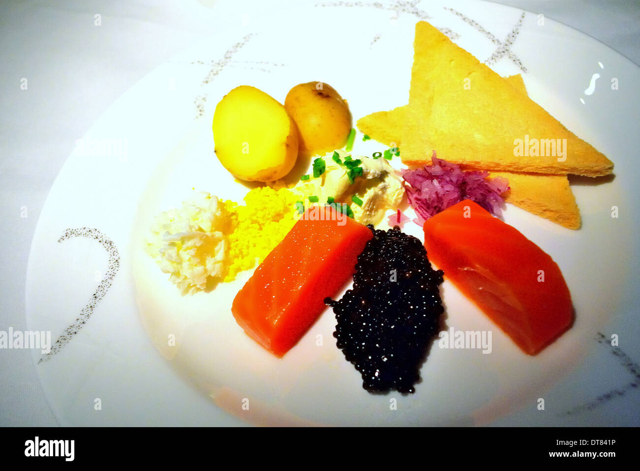 Eine Platte mit Kaviar und Lachs, serviert in einem Flugzeug in einer abgedunkelten Kabine. Stockfoto