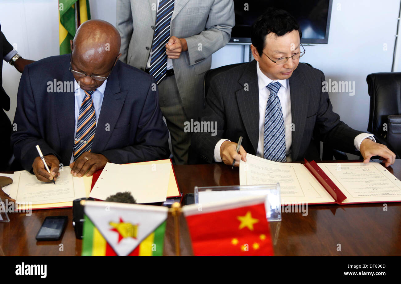 Harare, Simbabwe. 11. Februar 2014. Simbabwes Finanzen und wirtschaftliche Entwicklung Minister Patrick Chinamasa (L) und der chinesische Botschafter nach Simbabwe Lin Lin unterzeichnen eine Vereinbarung in Harare, Simbabwe, 11. Februar 2014. Simbabwe am Dienstag erhielt ein 23,3 Millionen US-Dollar aus China Infrastruktur Bau im ländlichen Raum. © Stringer/Xinhua/Alamy Live-Nachrichten Stockfoto