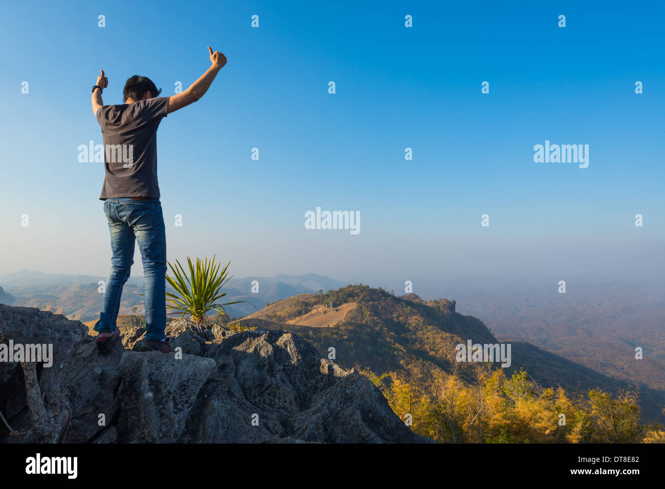 Mann auf Stein Gipfel des hohen Berges Stockfoto
