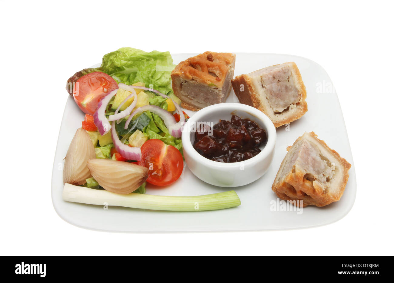 Snack Essen, Pork Pie, Gurke und Salat auf einem Teller isoliert gegen weiß Stockfoto