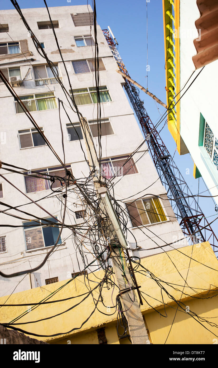 Strommasten und Kabel vor den Apartments. Puttaparthi, Andhra Pradesh, Indien Stockfoto