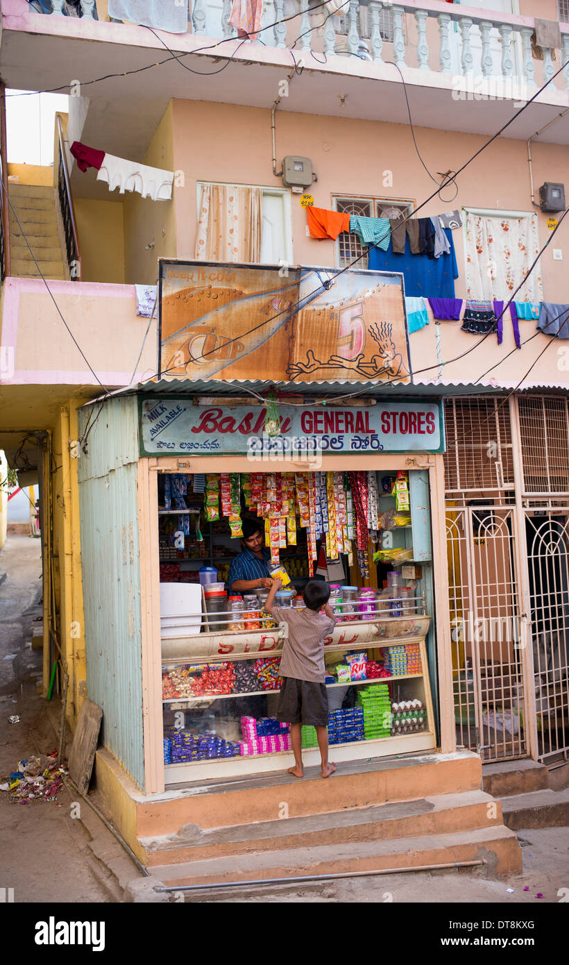 Indianerjunge Süßigkeiten aus einem Geschäft zu kaufen. Puttaparthi, Andhra Pradesh, Indien Stockfoto