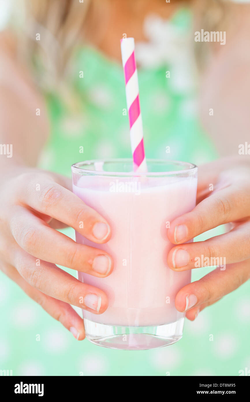 Nahaufnahme von Glas Smoothie Drink mit Stroh von jungen Mädchen in Händen gehalten Stockfoto