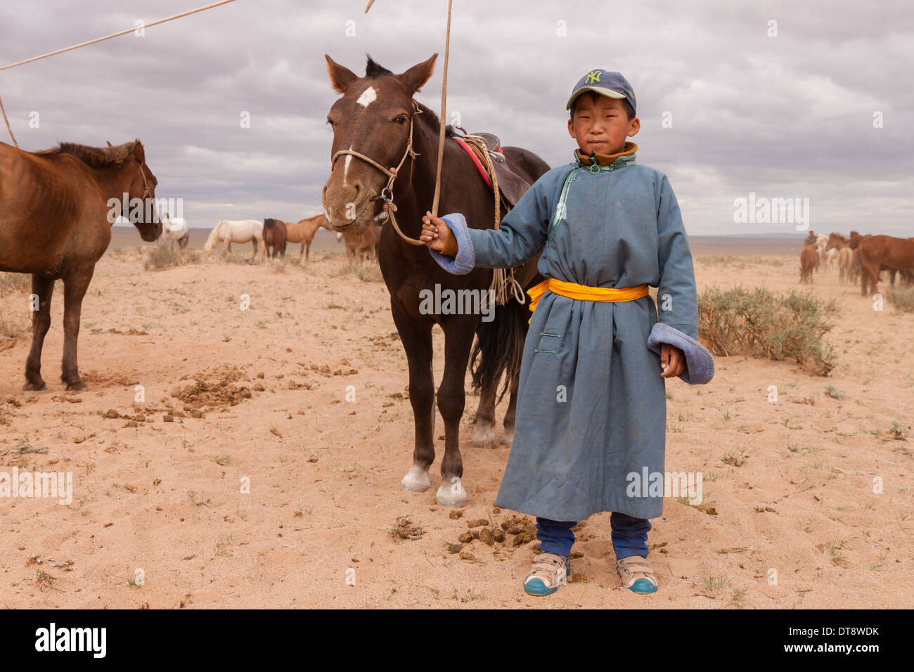 Ein junger mongolischer Nomade posiert mit einem Pferd Stockfoto