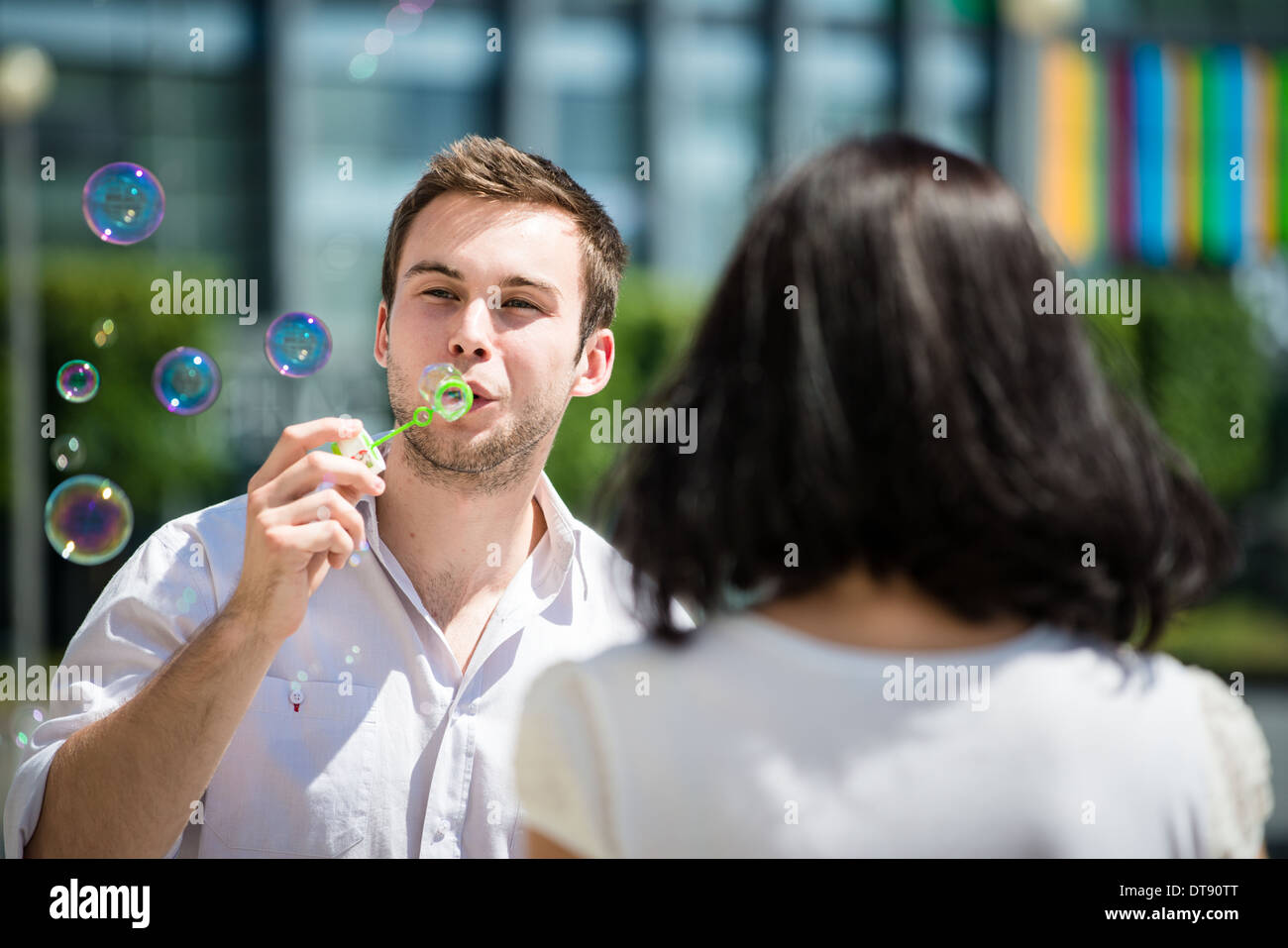 Mann bläst Luftblasen aus Blase Gebläse auf seine Freundin - Rückansicht Stockfoto