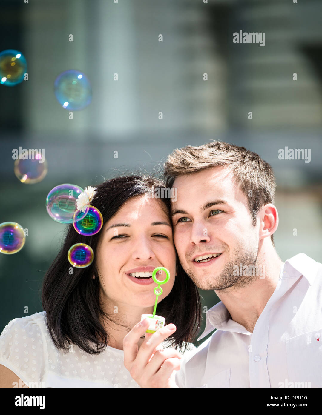 Junges Paar haben tolle Zeit zusammen mit Blase Gebläse - draußen in der Straße Stockfoto