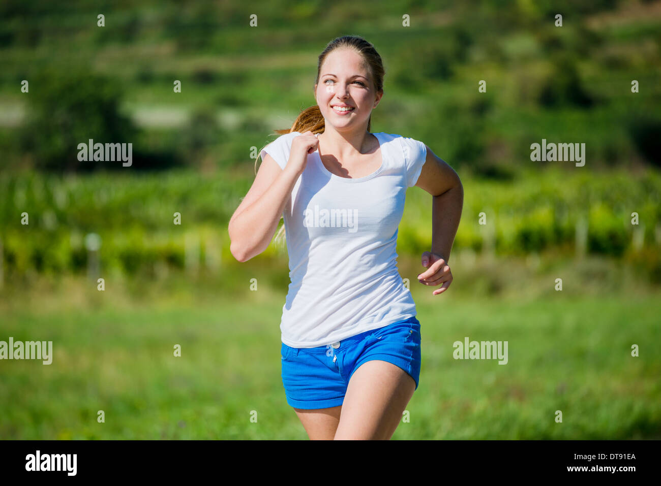 Junge schöne Frau (Teenager) Joggen in der Natur an sonnigen Tag Stockfoto